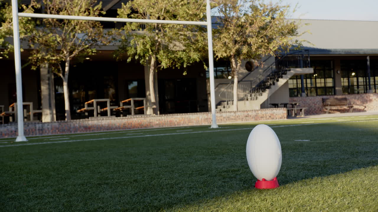 Rugby ball on tee in outdoor field, ready for kick-off during practice, copy space
