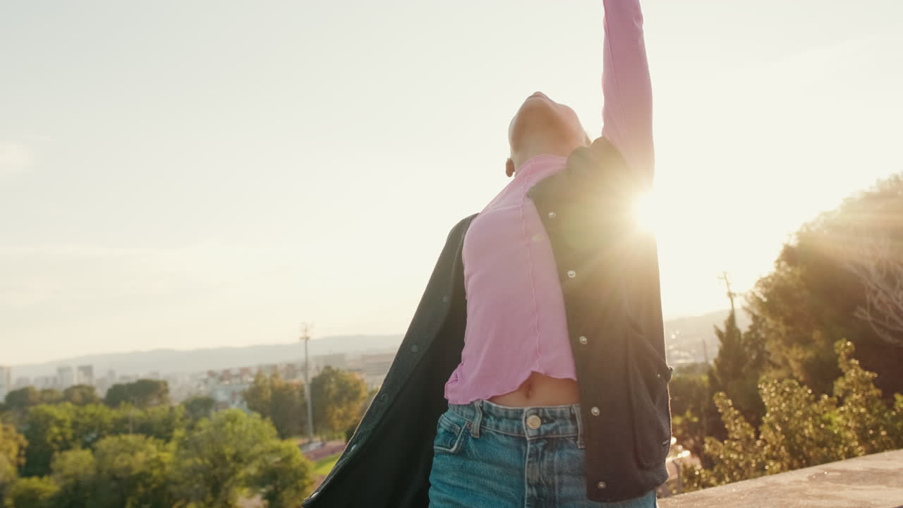 Young Woman Dances in the Park at Sunset