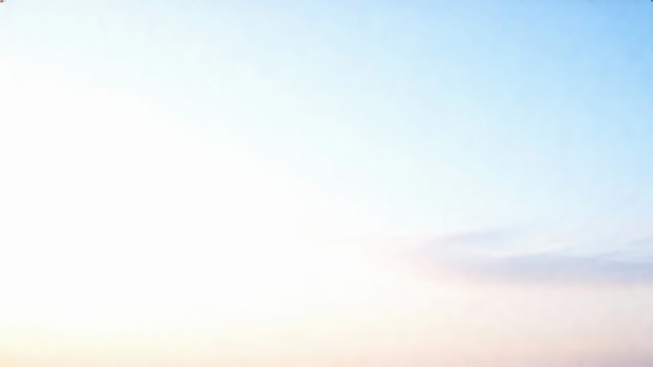 Holding steady wide camera, capturing clear sky over horizon at sunrise with faint wispy clouds
