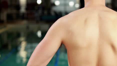 Fit-man-adjusting-his-goggles-at-the-pool