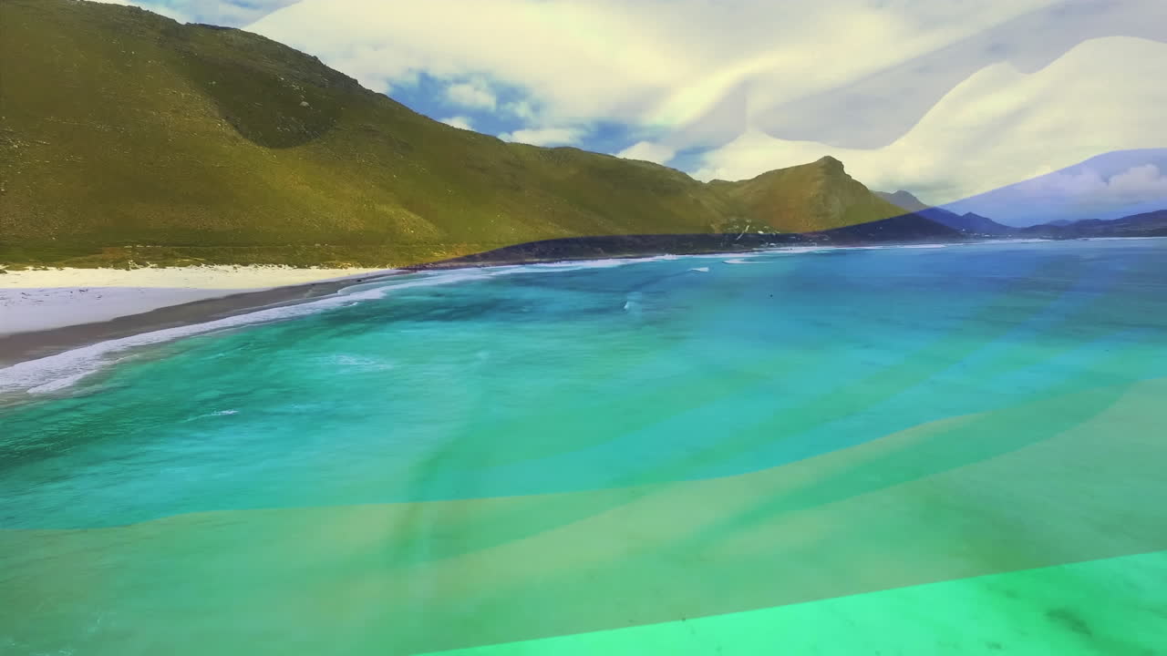 Digital composition of waving columbia flag against aerial view of the beach and the sea