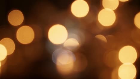 abstracto luminosas luces doradas borrosas en cámara lenta sobre fondo negro. navidad y año nuevo fondo bokeh