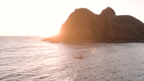 El-Hombre-Rema-A-Bordo-De-Un-Kayak-Rojo-Cerca-De-Las-Islas-Hawaianas-De-Na-Mokulua-Con-La-Puesta-De-Sol-En-El-Fondo