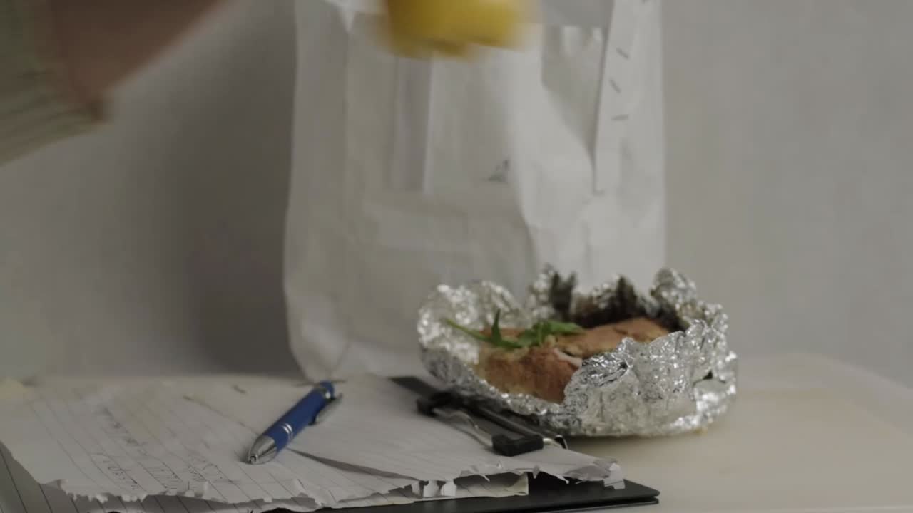 Busy worker takes a break to drink orange juice at desk