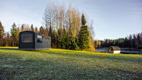 Static-shot-of-a-beautiful-cabin-beside-a-lake-surrounded-by-coniferous-tree-forest-on-a-cloudy-day-in-timelapse