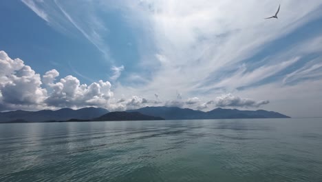 View from boat to Monkey Island in Nha Trang Vietnam. View the serene sea, distant mountains, and a bird flying by
