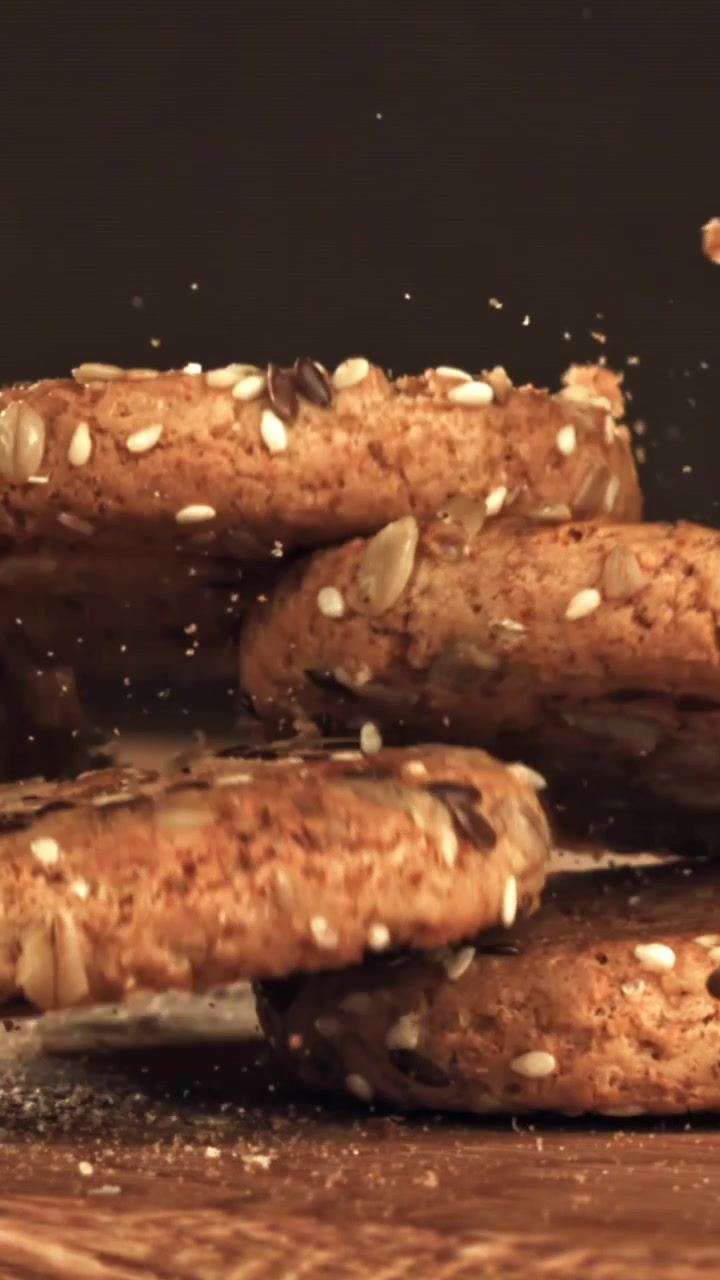 Rallentatore di biscotti sani ai semi che cadono su una superficie di legno