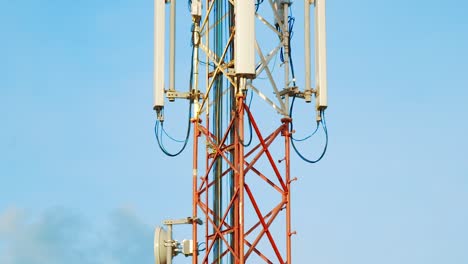 tilt up shot of cell tower against blue sky background in curacao