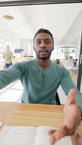 vertical video of portrait of happy african american businessman having video call in slow motion