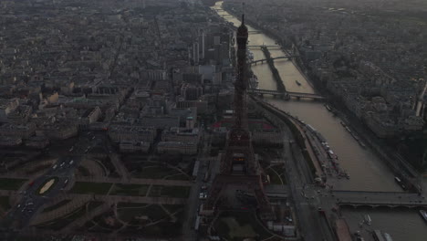 Aerial-panoramic-footage-of-town-development-in-metropolis.-Eiffel-Tower-and-Seine-river-flowing-through-urban-borough-at-dusk.-Paris,-France