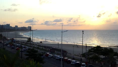 Aerial-steady-shot-high-in-the-sky-of-the-waves-crashing-onto-beach-at-sunset