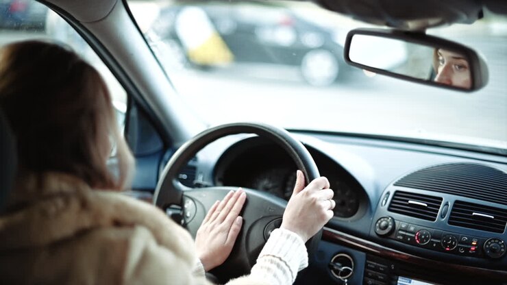 Donna che guida un'auto al rallentatore, mani sul volante