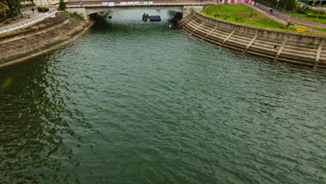 Drone-tilt-shot-of-waterway-bridge-for-pedestrians-in-Hongkong-city,-China