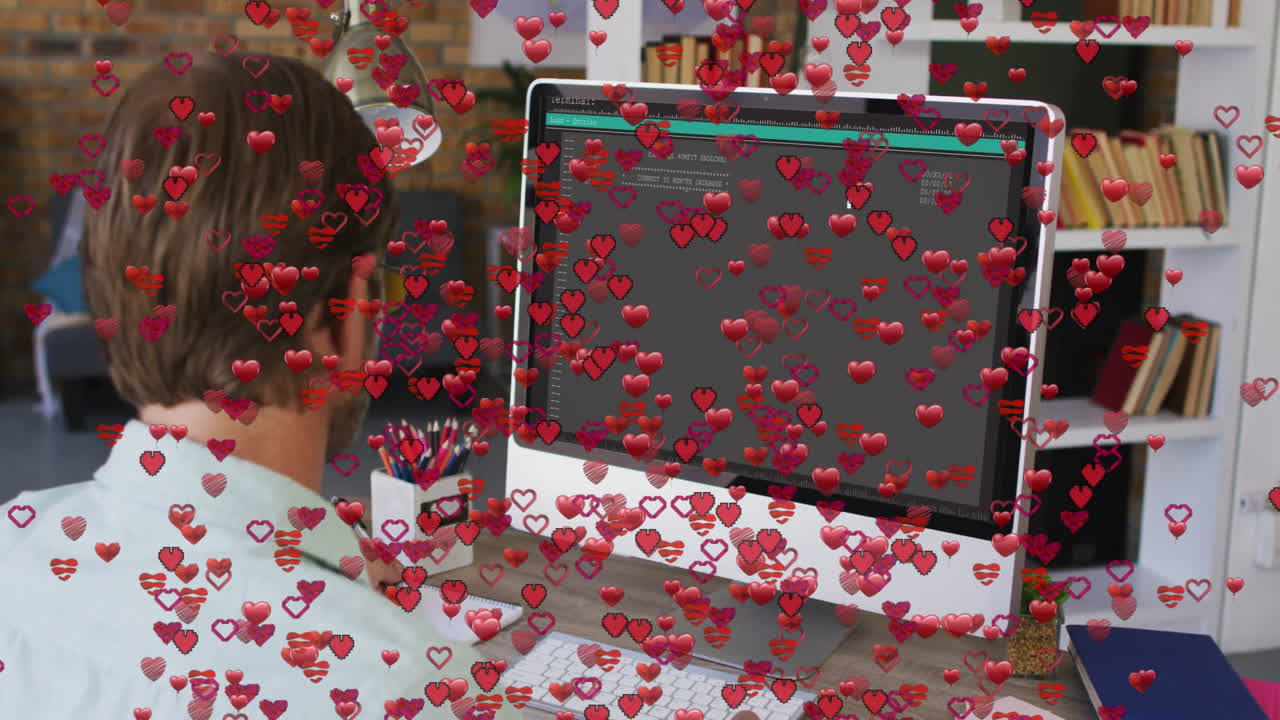 Person working at desk with red heart animation over computer screen