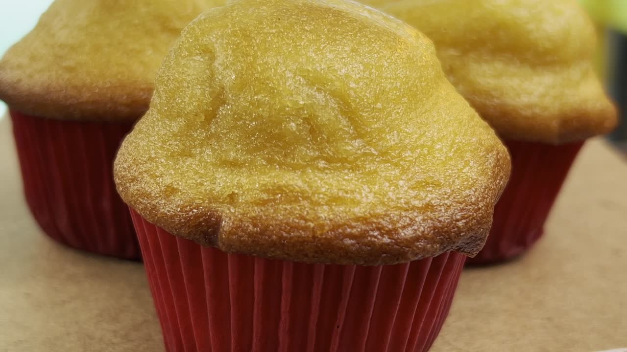 나무 표면 에 앉아 있는 밝은 빨간색 컵케이크 라인 에 새로 구운 황금 머핀