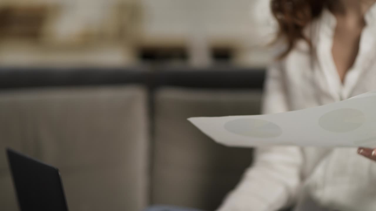 Young woman working at home. Closeup female person sitting on sofa with laptop.