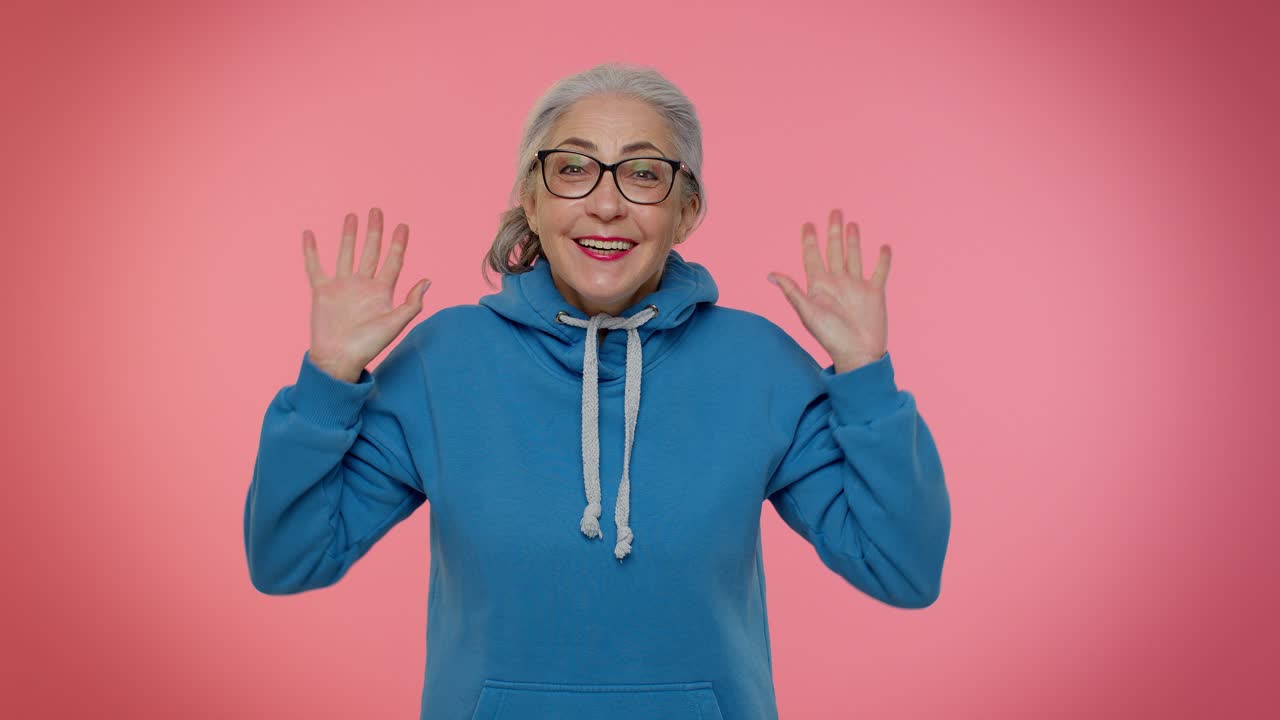 una mujer con una sudadera azul sonríe y mira a la cámara.
