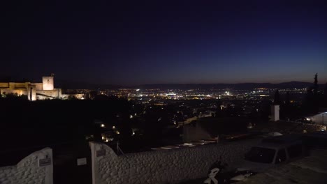 Blick-Auf-Die-Alhambra-Mit-Langsamem-Schwenk-Auf-Die-Stadt-Granada-Rechts-In-Der-Nacht