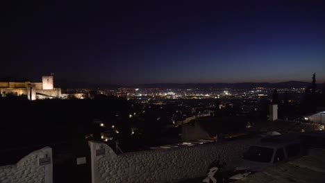 vista de la alhambra con panorámica lenta a la ciudad de granada a la derecha durante la noche