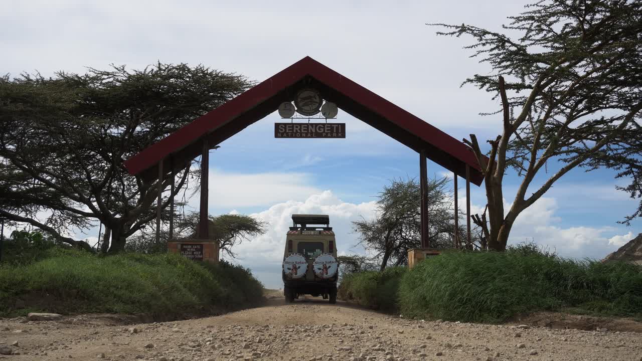사파리 입구 아래에서 운전하는 사파리 투어 차량의 정적인 낮은 앵글 샷