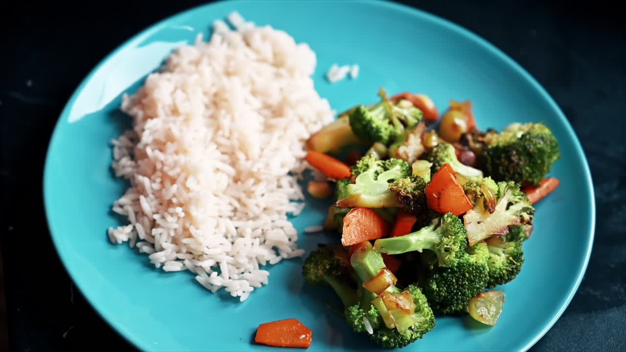 A man putting rice and a healthy salad on a plate