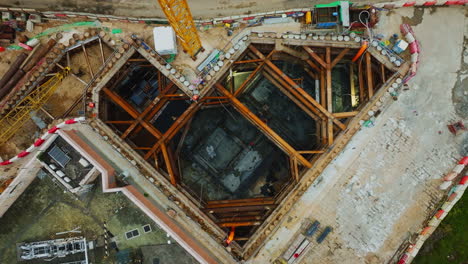 drone en ascenso disparó sobre un sitio de construcción con una grúa y un edificio en construcción con vista a un hermoso lago