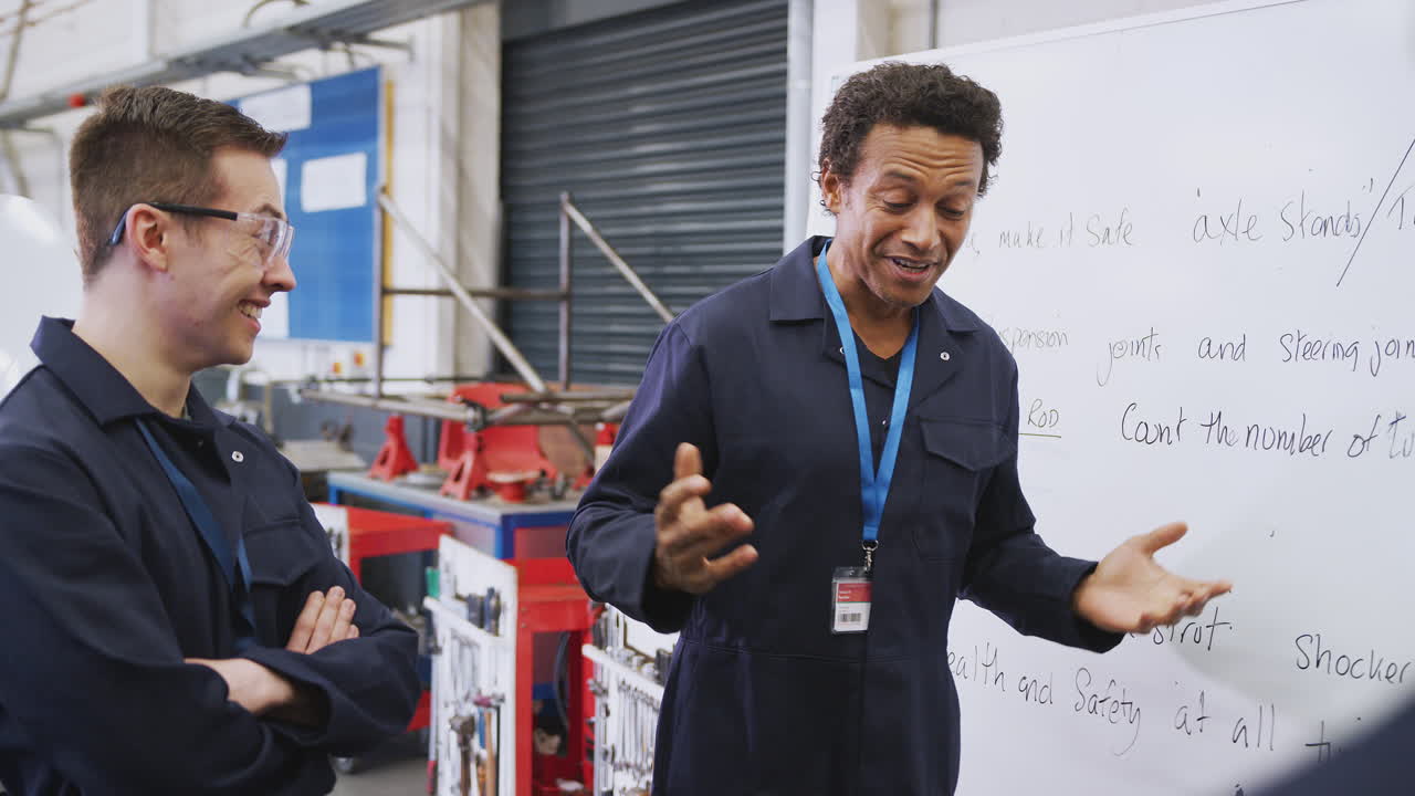 tutor masculino por pizarra con estudiantes que enseñan aprendizaje de mecánico de automóviles en la universidad