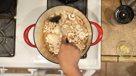 sauteing organic sliced mushrooms in a pot over the stove for a vegan recipe - overhead view wild rice series