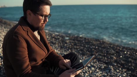 hombre usando tableta en la playa
