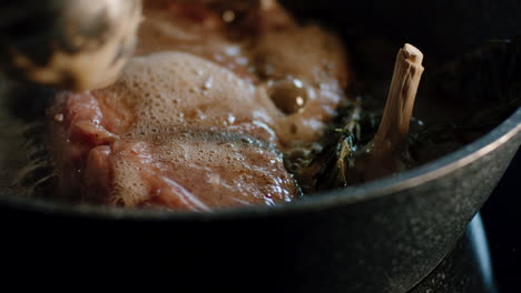 Preparing-steak-for-dinner-in-hot-pan-basting-liquid-fat-on-meat,-sizzling