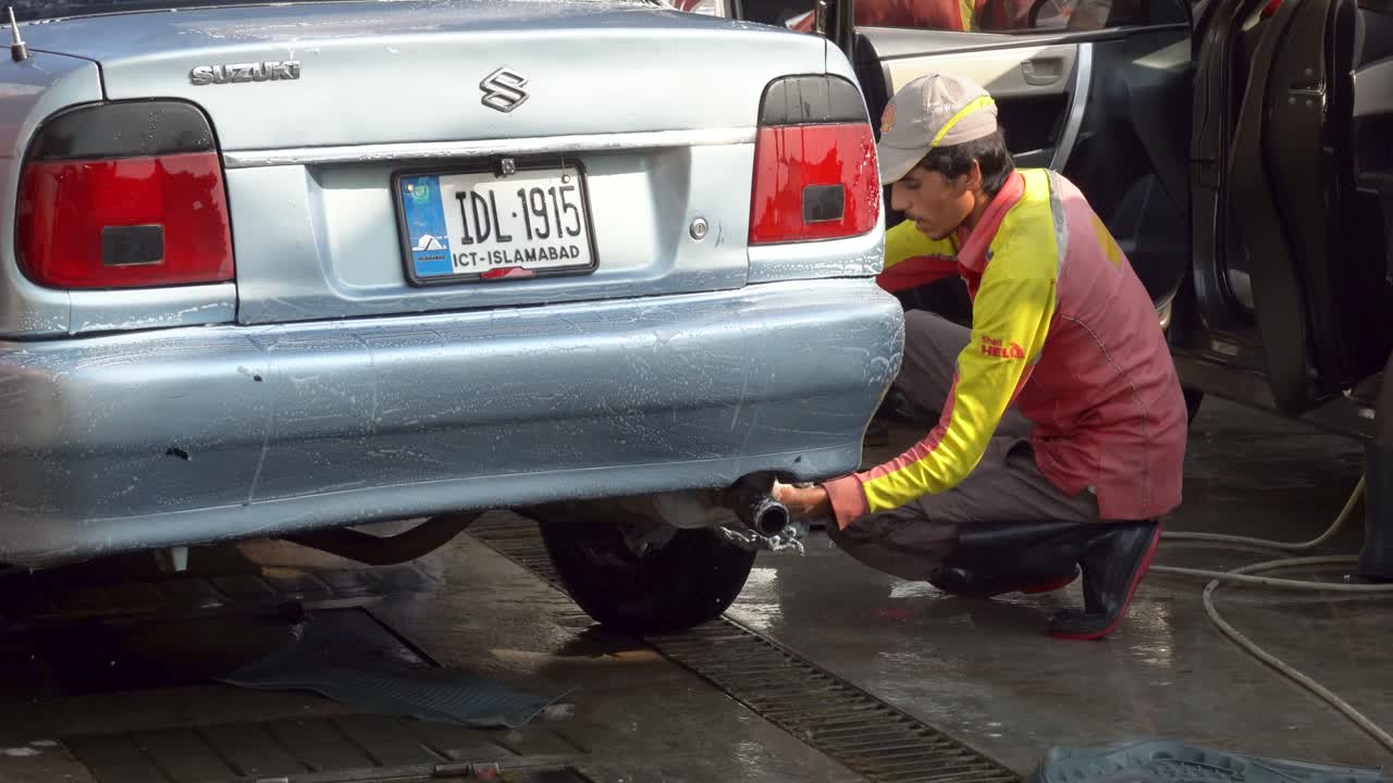 Experience a detailed car wash as dedicated staff meticulously clean car tires using a soapy cloth, ensuring the vehicle looks its best!