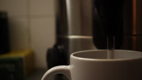 Dolly-right,-close-up-of-boiling-water-being-poured-into-coffee-cup