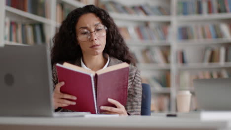 woman studying and reading a book in a library