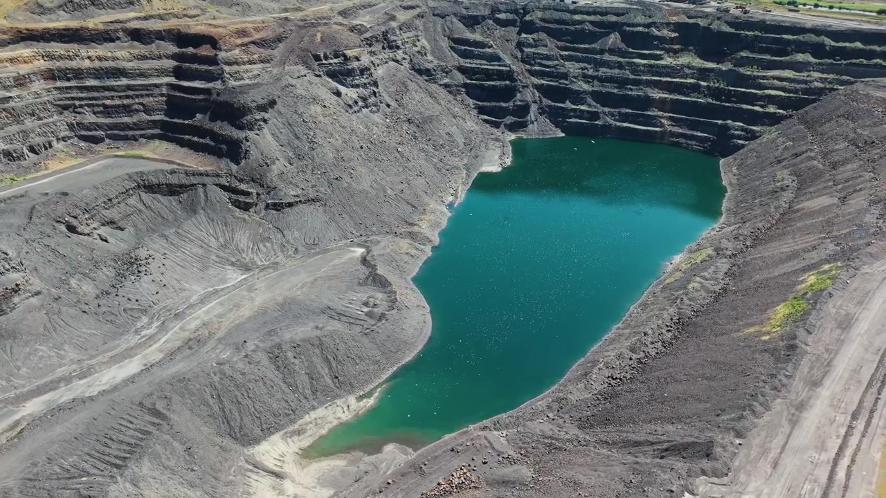 Open pit mine void filled with water at Ffos-y-Fran near Merthyr Tydfil, steep excavated terraces, environmental damage in South Wales