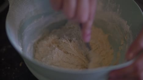 woman hands stirring pizza batter with spoon