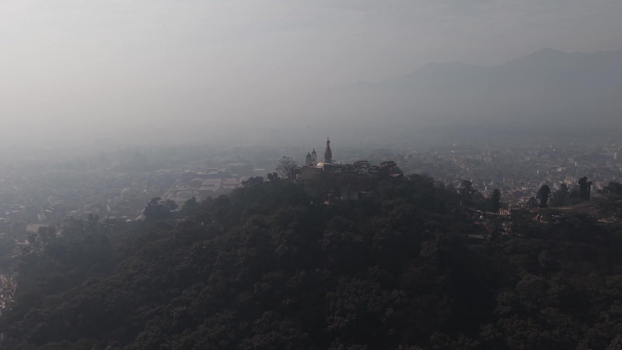 Ripresa aerea con drone dello stupa di Swayambhunath su una collina boscosa a Kathmandu, Nepal.