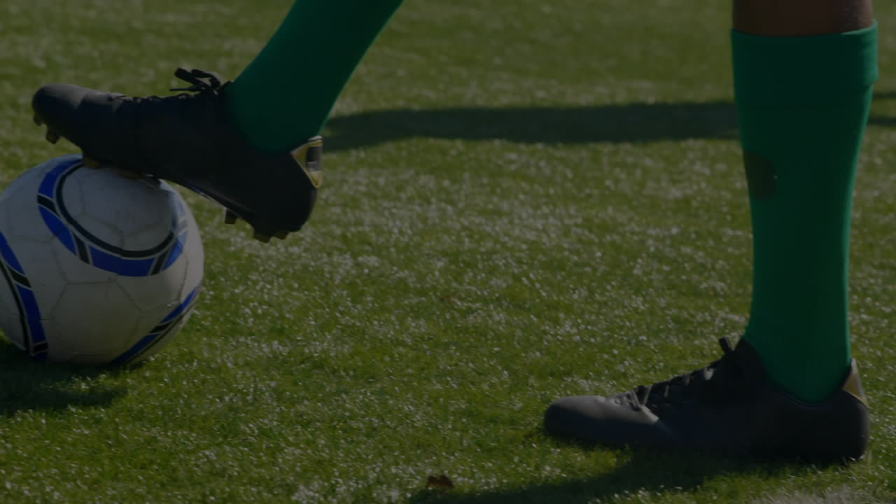Animasi grafik dan data keuangan di atas kaki pemain sepak bola pria beragam yang sedang berlatih