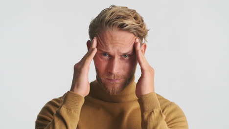 man in brown sweater with headache