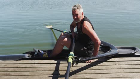 Portrait-of-senior-caucasian-man-preparing-rowing-boat-in-a-river