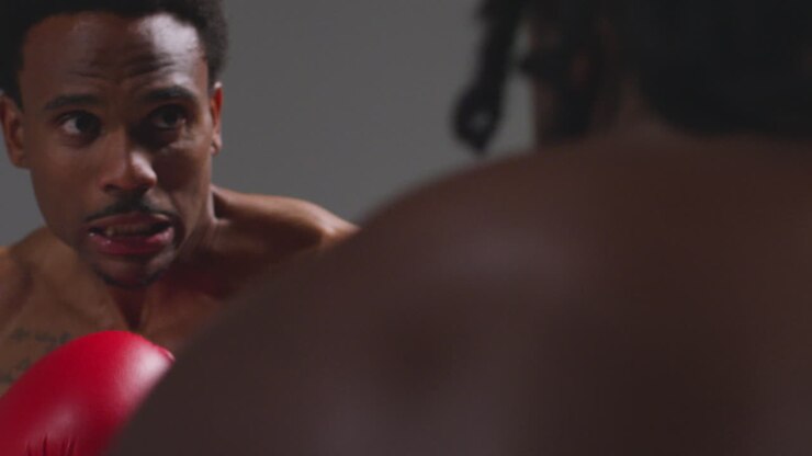 Close Up Studio Shot Of Two Male Boxers Wearing Gloves Fighting In Boxing Match Against Grey Background 11