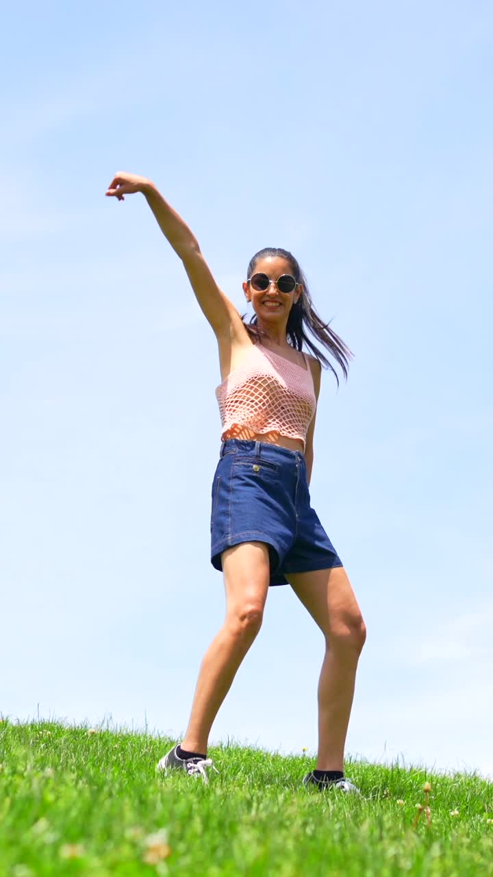 Woman Poses in Front of Grass and Blue Sky