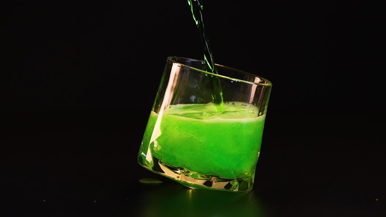 녹색 액체가 기울어진 유리통에 부어서 거품이 생기죠.