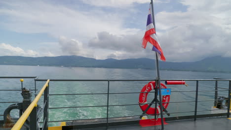 Bandera-Tailandesa-Ondeando-Majestuosamente-En-El-Viento-Tras-El-Ferry-Detrás