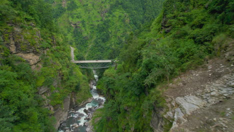 landscape of nepal, river flowing between hills, ridges, greenery environment, cliffs trees and bridges