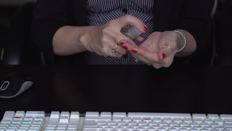 Female office worker cleans hands with antibacterial gel