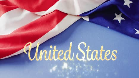 Animation-of-sparkling-united-states-text-over-flag-of-america-on-blue-background