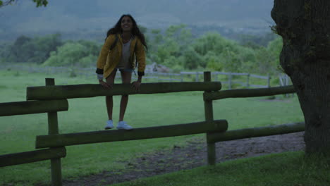 Joven-Mujer-India-Independiente-Sentada-En-La-Valla-Disfrutando-De-Un-Hermoso-Campo-Verde-Granja-Sonriendo-Alegre-Contemplación-Descansando-Bajo-Un-árbol