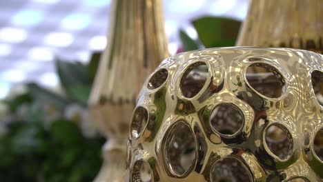 detail of a golden vase on a table set for a social event