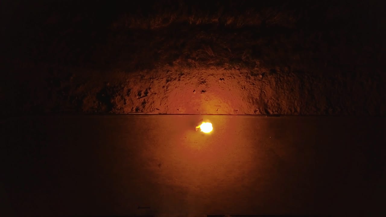 un joven hombre rubio exhala una gran corriente de fuego haciendo un disparo aéreo de bola de fuego