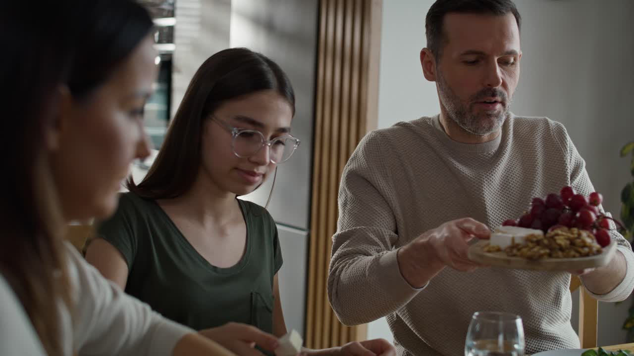 세 명 의 백인 가족 이 함께 아침 식사 를 나누고 있다